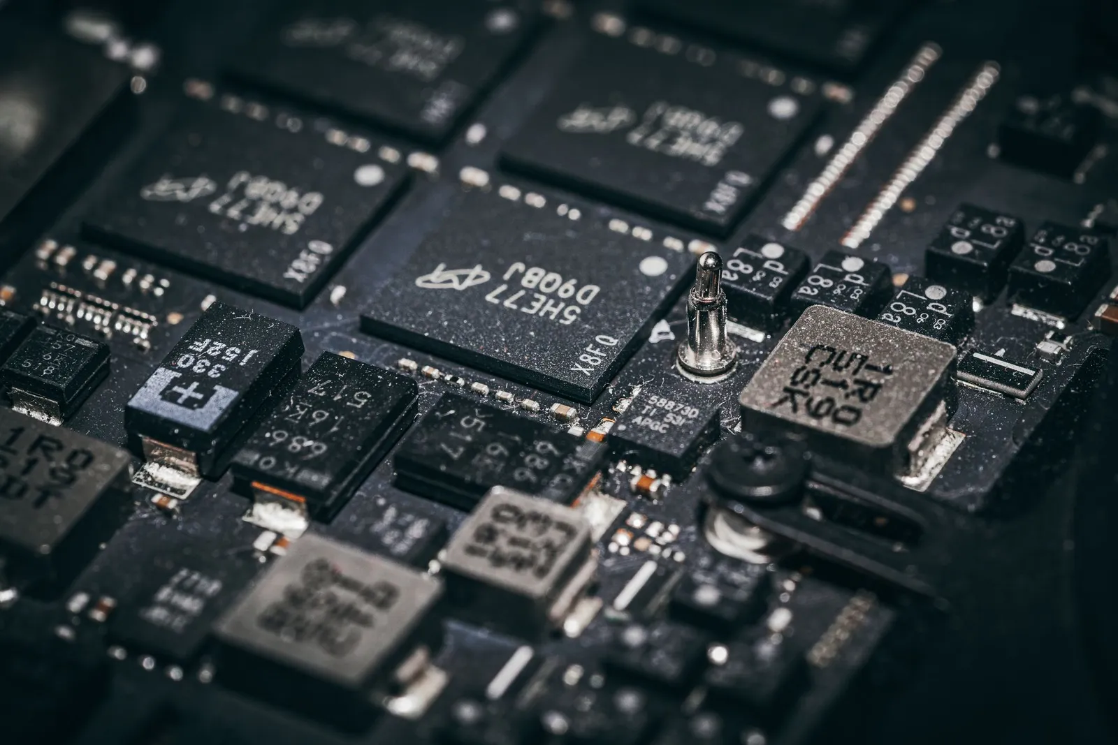 Close-up of microchips and components on a dark printed circuit board